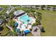 Aerial view of the community pool, sundeck, playground, and clubhouse surrounded by lush landscaping at 19418 Butterwood Ln, Lutz, FL 33558