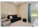 Small bedroom featuring a black futon and neutral color scheme and natural light at 19418 Butterwood Ln, Lutz, FL 33558