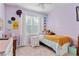 Cozy bedroom featuring lavender walls, carpeted flooring, a twin bed, and a window with sheer white curtains at 19418 Butterwood Ln, Lutz, FL 33558