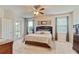 Bright bedroom featuring a ceiling fan, neutral walls, and large windows for ample natural light at 19418 Butterwood Ln, Lutz, FL 33558