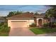 Charming single-story home with a well-manicured lawn, inviting entrance, and neutral paint scheme with a brown roof at 19418 Butterwood Ln, Lutz, FL 33558