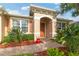 Close-up of the front entrance with an arched entryway, well-maintained landscaping, and brick walkway leading to the front door at 19418 Butterwood Ln, Lutz, FL 33558