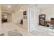Hallway featuring tiled floors, arched doorways, and view into a home office with glass paneled door at 19418 Butterwood Ln, Lutz, FL 33558