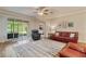 Comfortable living room featuring hardwood floors, ceiling fan, and screened patio at 19418 Butterwood Ln, Lutz, FL 33558