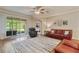 Comfortable living room featuring hardwood floors, ceiling fan, and screened patio at 19418 Butterwood Ln, Lutz, FL 33558