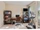 Well-lit office space featuring neutral walls, carpeted flooring, a desk, shelving units, and natural light at 19418 Butterwood Ln, Lutz, FL 33558