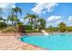 Community pool with a slide and palm trees and plenty of space for recreation at 19418 Butterwood Ln, Lutz, FL 33558