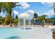 Community pool featuring a splash fountain, palm trees, sun deck, and a play area at 19418 Butterwood Ln, Lutz, FL 33558