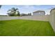 Large backyard featuring green grass and a white vinyl fence at 21284 Southern Charm Dr, Land O Lakes, FL 34637