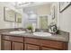 Bathroom featuring a double sink vanity with granite countertops and a large mirror at 21284 Southern Charm Dr, Land O Lakes, FL 34637