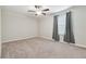 Spacious bedroom features neutral carpet, ceiling fan, and a window with curtains offering comfortable living at 21284 Southern Charm Dr, Land O Lakes, FL 34637