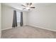 Spacious bedroom features neutral carpet, ceiling fan, window with curtains, offering comfortable living at 21284 Southern Charm Dr, Land O Lakes, FL 34637