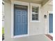 Close-up of a blue front door with a window and traditional hardware at 21284 Southern Charm Dr, Land O Lakes, FL 34637
