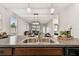 Open-concept kitchen with stainless sink, granite countertops, and pendant lighting overlooking the living area at 21284 Southern Charm Dr, Land O Lakes, FL 34637