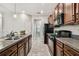 Well-lit kitchen showcasing granite countertops, stainless sink, tile flooring, and modern black appliances at 21284 Southern Charm Dr, Land O Lakes, FL 34637