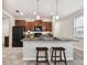 Kitchen island with granite countertops, black appliances, and dark wood cabinets provides additional seating at 21284 Southern Charm Dr, Land O Lakes, FL 34637