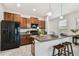 Well-equipped kitchen featuring dark wood cabinetry, black appliances, and an island with bar seating at 21284 Southern Charm Dr, Land O Lakes, FL 34637