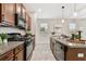 Bright kitchen featuring modern black appliances, tile floors, granite countertops, and ample cabinet space at 21284 Southern Charm Dr, Land O Lakes, FL 34637