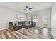 Bright living room features stylish wood-look tile flooring and a comfortable gray sectional sofa at 21284 Southern Charm Dr, Land O Lakes, FL 34637