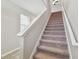 Carpeted stairway featuring white banisters and a window at the landing, leading to the upper floor at 21284 Southern Charm Dr, Land O Lakes, FL 34637