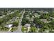 An aerial view displays a charming single-Gathering home with mature trees, a large driveway, and well-maintained landscaping at 21426 Quesada Ave, Port Charlotte, FL 33952