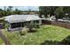 Aerial view of a fenced yard with green grass, trees, and the home's exterior at 21426 Quesada Ave, Port Charlotte, FL 33952