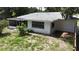 Exterior view of home with white walls, screened-in porch and partially grass backyard at 21426 Quesada Ave, Port Charlotte, FL 33952