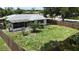 Aerial view of a fenced-in backyard, showcasing green grass, trees, and the home's exterior at 21426 Quesada Ave, Port Charlotte, FL 33952