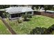 Backyard view with a wooden fence, green grass and trees surrounding the property at 21426 Quesada Ave, Port Charlotte, FL 33952