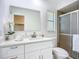 Updated bathroom features a white vanity with quartz countertop and walk-in shower at 21426 Quesada Ave, Port Charlotte, FL 33952