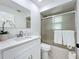 A sleek bathroom features a white vanity, mirror, and shower with sliding glass doors at 21426 Quesada Ave, Port Charlotte, FL 33952