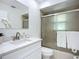 Bathroom featuring a white vanity, large mirror, and shower with glass doors at 21426 Quesada Ave, Port Charlotte, FL 33952