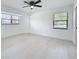 A bright bedroom with light floors, a ceiling fan, and large windows at 21426 Quesada Ave, Port Charlotte, FL 33952