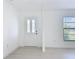 Entryway featuring a white front door with windows, bright white walls and light wood floors at 21426 Quesada Ave, Port Charlotte, FL 33952
