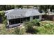 Exterior shot of home with screened-in porch, white walls, and partially grass backyard at 21426 Quesada Ave, Port Charlotte, FL 33952