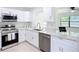 Modern kitchen showcasing stainless steel appliances, sleek countertops, and classic white cabinets for a stylish cooking space at 21426 Quesada Ave, Port Charlotte, FL 33952