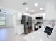 Well-lit kitchen boasts stainless appliances, white cabinetry, and ample counter space, merging style with practical functionality at 21426 Quesada Ave, Port Charlotte, FL 33952