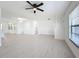 Bright, open living room with modern light wood floors, a ceiling fan, and views of the kitchen and entryway at 21426 Quesada Ave, Port Charlotte, FL 33952