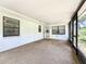 Enclosed sunroom featuring carpet floors, white walls, and windows with backyard views at 21426 Quesada Ave, Port Charlotte, FL 33952