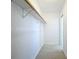 Bright walk-in closet with wood shelf, white walls and light wood-look floors at 21426 Quesada Ave, Port Charlotte, FL 33952