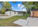 View of the back exterior with a mix of grass, patio, and an enclosed porch area at 221 S Kingsway Rd, Seffner, FL 33584