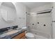 Bathroom with wood vanity, granite countertop, round mirror and tiled shower with glass doors at 221 S Kingsway Rd, Seffner, FL 33584