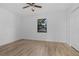 Charming bedroom with wood floors, a ceiling fan, and a view of the outdoors at 221 S Kingsway Rd, Seffner, FL 33584