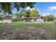 A white one-story house with an enclosed patio and a detached shed on a spacious lawn at 221 S Kingsway Rd, Seffner, FL 33584