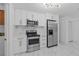 Modern kitchen with stainless steel appliances, white cabinets, and marble backsplash at 221 S Kingsway Rd, Seffner, FL 33584