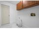 Bright laundry room features sleek marble floors, upper cabinets, and washer-dryer hookups at 221 S Kingsway Rd, Seffner, FL 33584