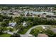 An aerial view showcases a community with lush trees, a pond and neighborhood streets at 22946 Brownwood Ct, Land O Lakes, FL 34639