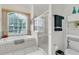 Bathroom featuring garden tub, glass enclosed shower, and large window at 22946 Brownwood Ct, Land O Lakes, FL 34639