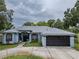 Charming blue home featuring a well-manicured lawn and a two-car garage at 22946 Brownwood Ct, Land O Lakes, FL 34639