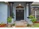 Close up of the home's front door with columns, new paint and mature landscaping at 22946 Brownwood Ct, Land O Lakes, FL 34639
